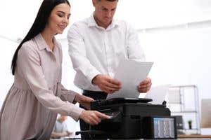 man and woman using a printer in an office